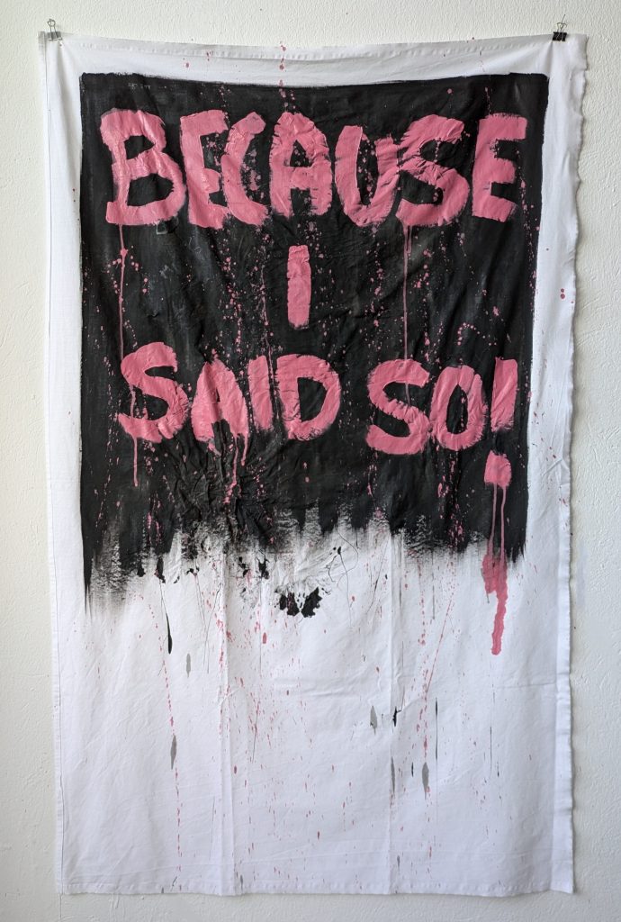 Kunstwerk, dass den Schriftzug "Because I said so!" in großer pinker Schrift auf schwarzem Hintergrund zeigt. beides ist mit Acryl auf DDR-Tischtuch gemalt. Das Tischtuch ist mit Farbe bespritzt und zerknittert.